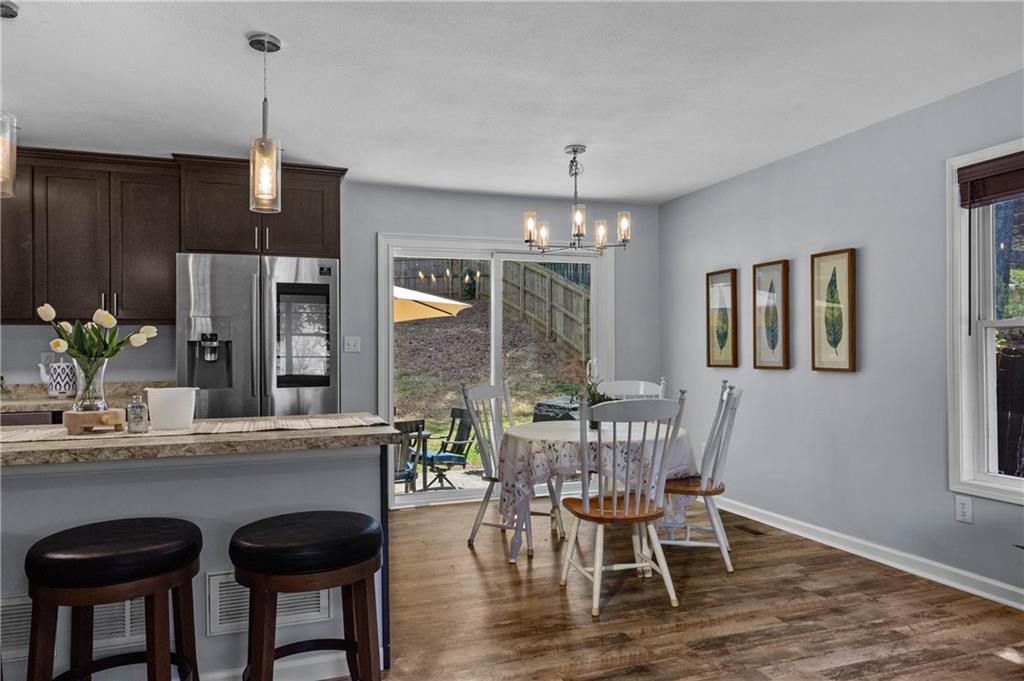 3990 Pine Mountain Road Northwest Kennesaw, GA 30152 - Photo 13 of 32 a dining room with furniture a chandelier and wooden floor