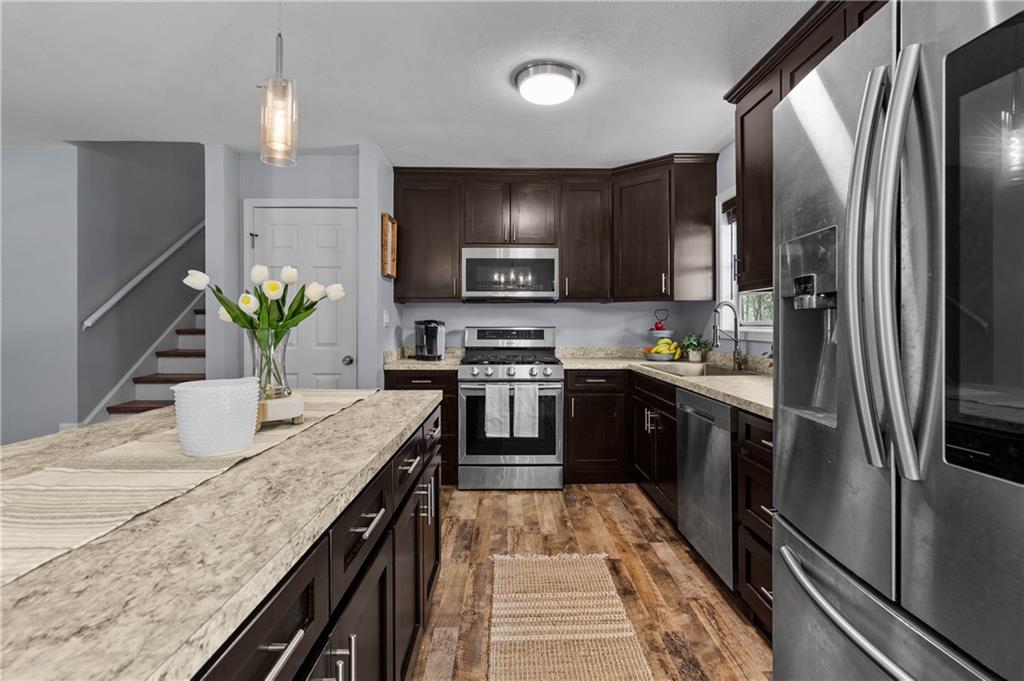 3990 Pine Mountain Road Northwest Kennesaw, GA 30152 - Photo 9 of 32 a kitchen with stainless steel appliances granite countertop a sink a stove and a refrigerator