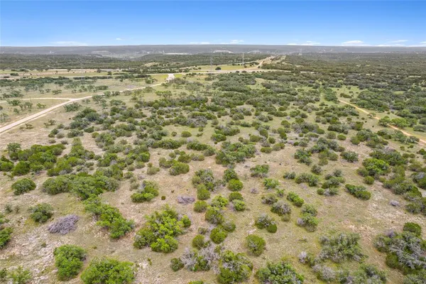 an aerial view of residential houses with outdoor space and ocean view