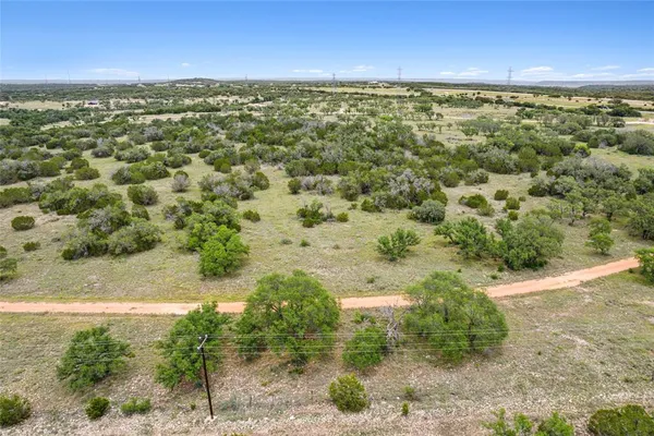an aerial view of residential houses with outdoor space and trees