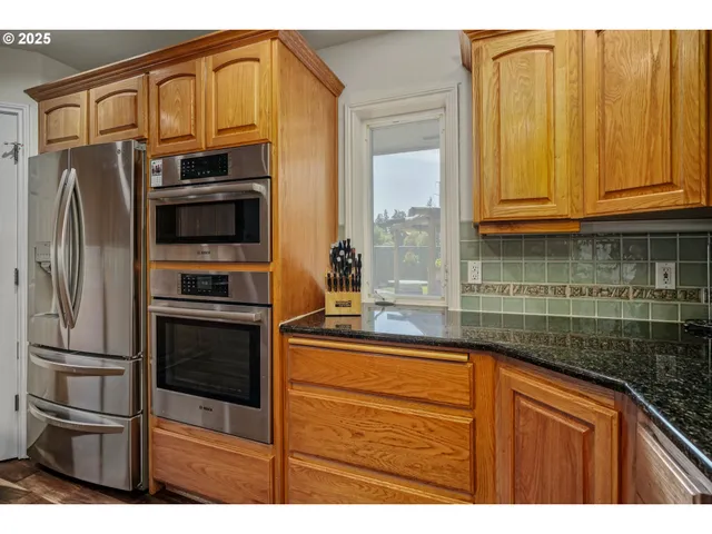 a kitchen with stainless steel appliances granite countertop a refrigerator and a sink