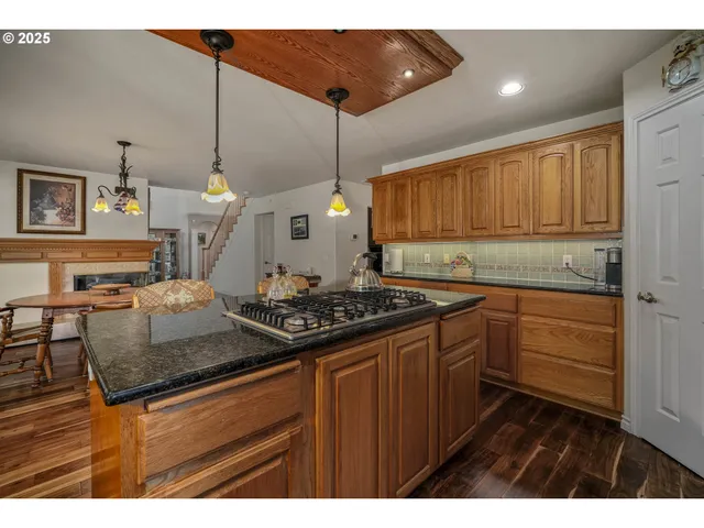 a kitchen with kitchen island granite countertop wooden cabinets and white appliances