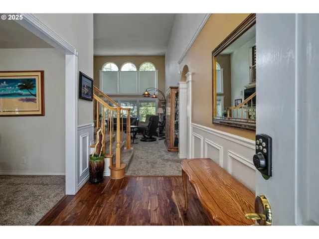 a view of a hallway with wooden floor and livingroom