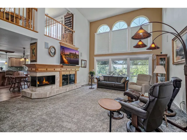 a living room with furniture a fireplace and a floor to ceiling window
