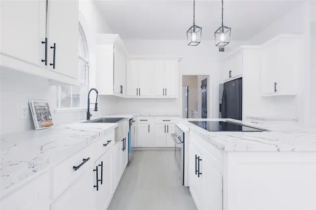 a kitchen with white cabinets and window
