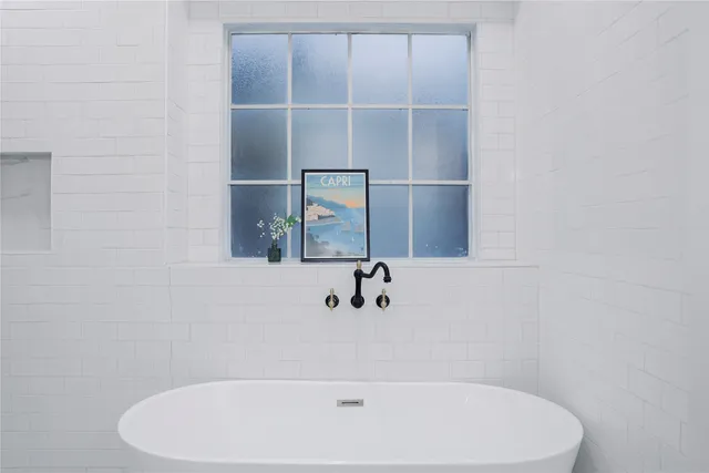 a white bath tub sitting next to a shower