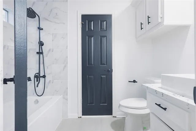 a bathroom with a white tub a sink and mirror