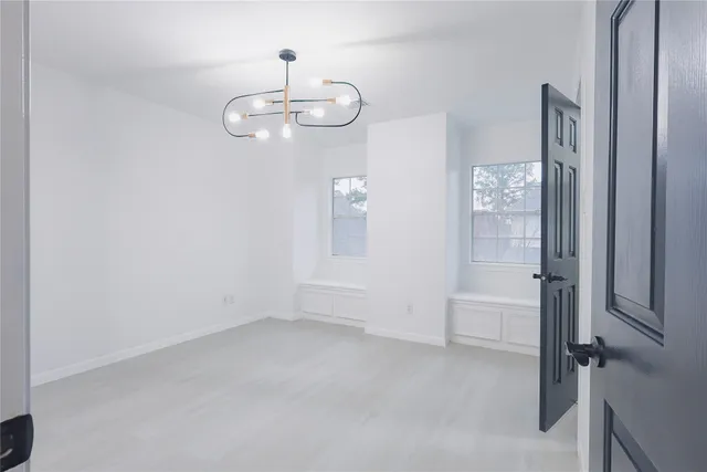 a view of empty room with wooden floor and windows