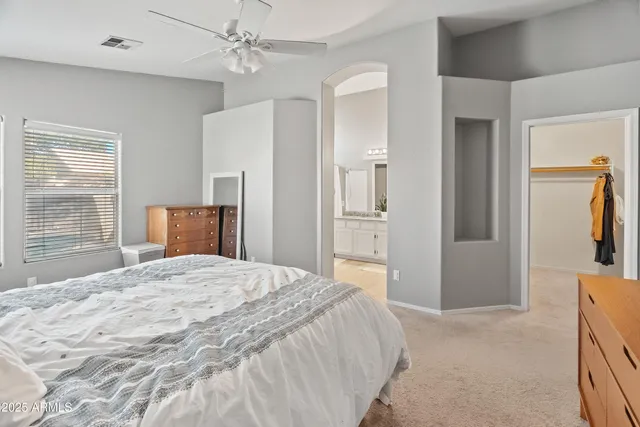 a spacious bedroom with a bed and a dresser