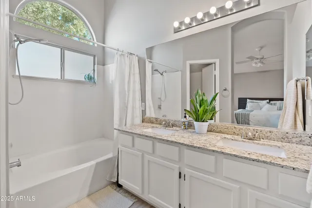 a bathroom with a granite countertop sink a large mirror and a bathtub