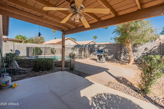 a view of a patio with a table and chairs under an umbrella