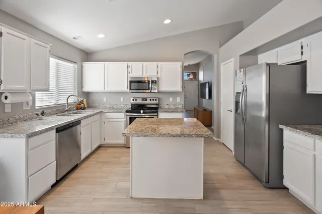 a kitchen with stainless steel appliances granite countertop a refrigerator and a stove top oven