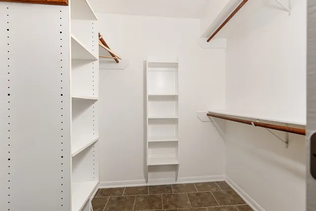 a view of walk in closet with empty racks