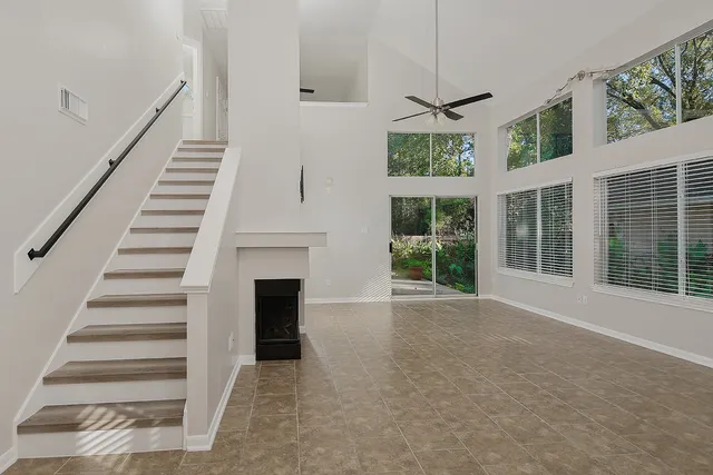 a view of an empty room with wooden floor and a fireplace