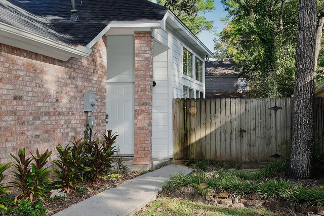 a brick house with a flower garden in front of it