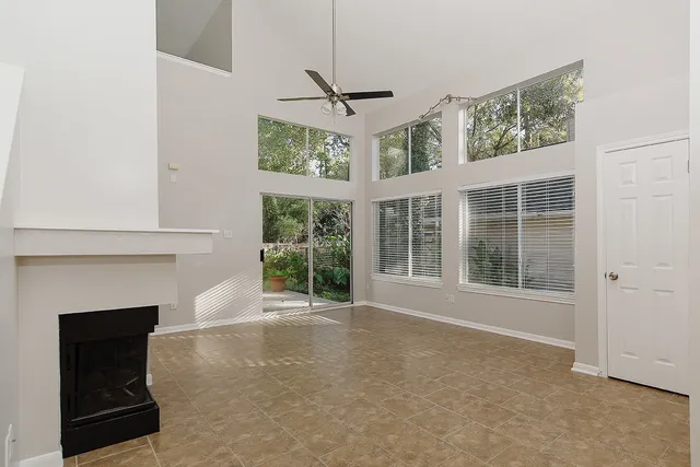 a view of an empty room with a fireplace and a window