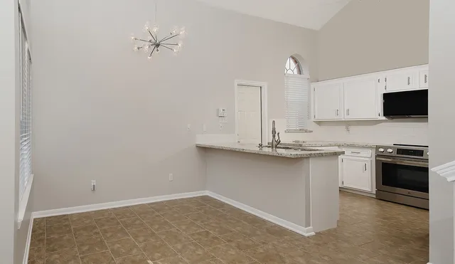 a kitchen with granite countertop a sink cabinets and stainless steel appliances