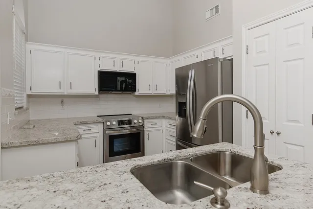 a kitchen with a sink cabinets and stainless steel appliances