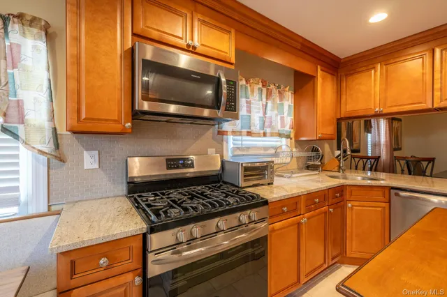 a kitchen with stainless steel appliances a stove a sink and a microwave