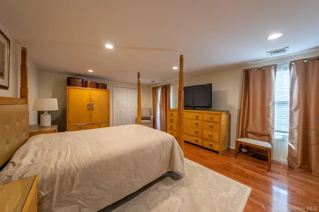 a spacious bedroom with a bed and a flat screen tv