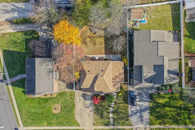 an aerial view of a house with swimming pool and large trees