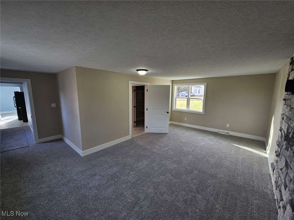 5961 State Rte 213 Toronto, OH 43964 - Photo 6 of 15 Carpeted spare room featuring a textured ceiling