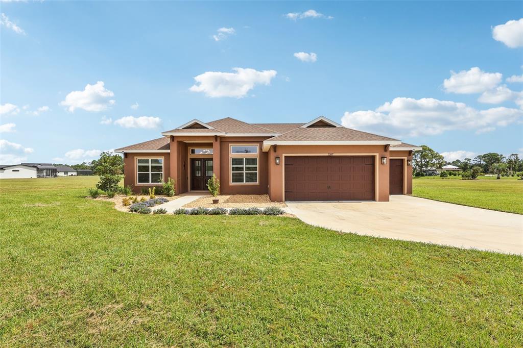 a front view of a house with a garden and yard