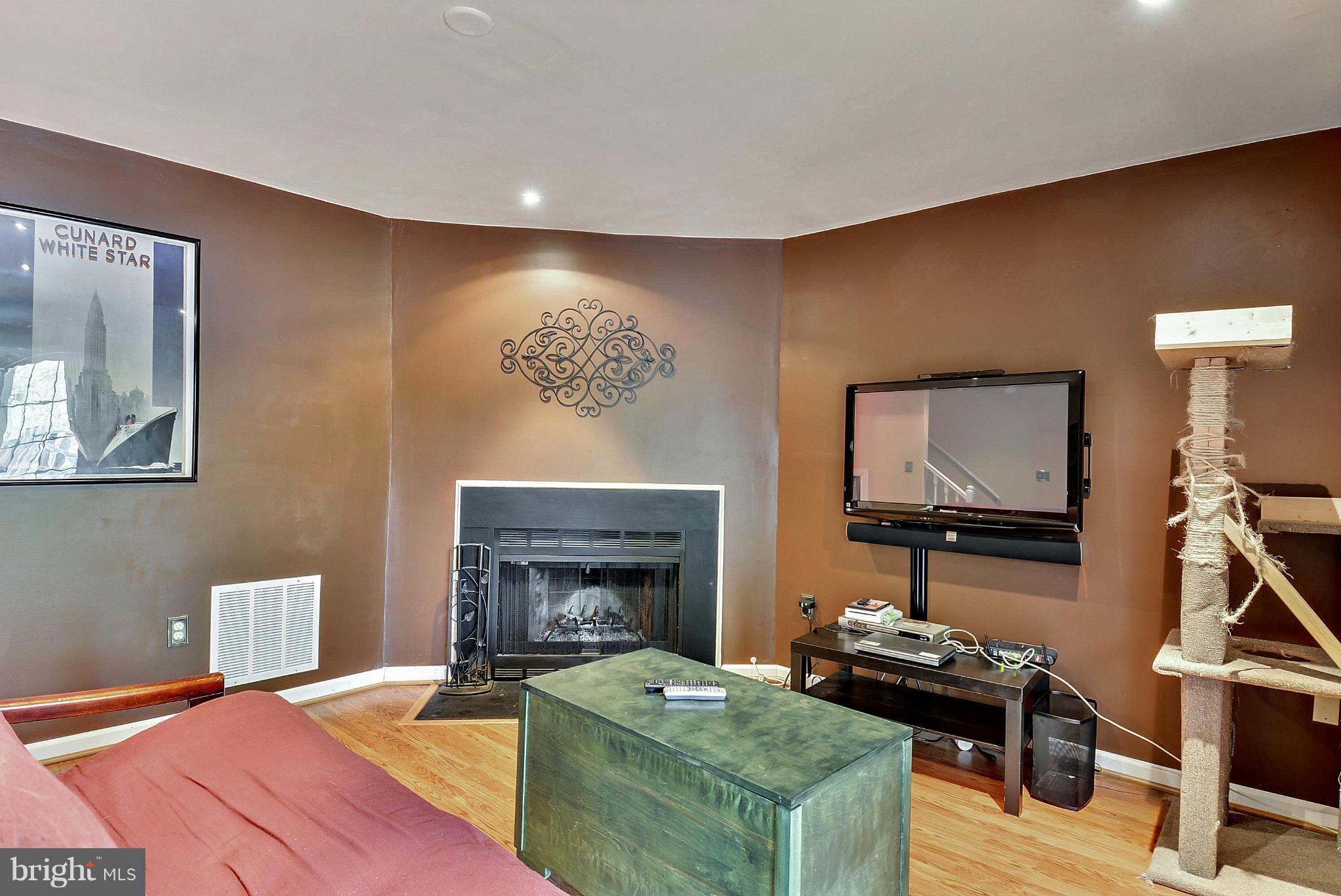3841 Ferrara Drive Silver Spring, MD 20906 - Photo 19 of 30 a living room with furniture a flat screen tv and a fireplace