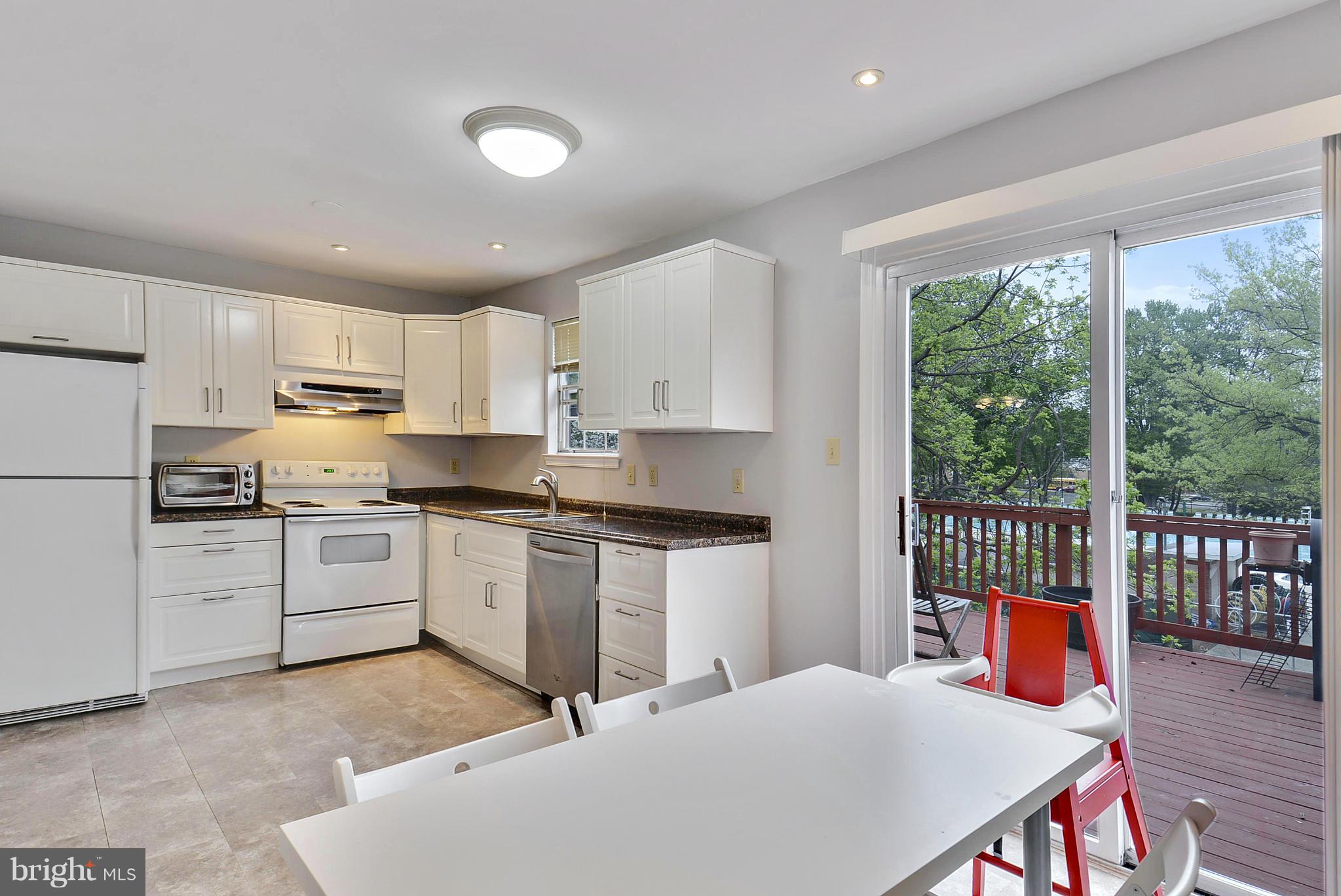 3841 Ferrara Drive Silver Spring, MD 20906 - Photo 4 of 30 a kitchen with stainless steel appliances kitchen island granite countertop a refrigerator a sink dishwasher a stove and white countertops with wooden floor