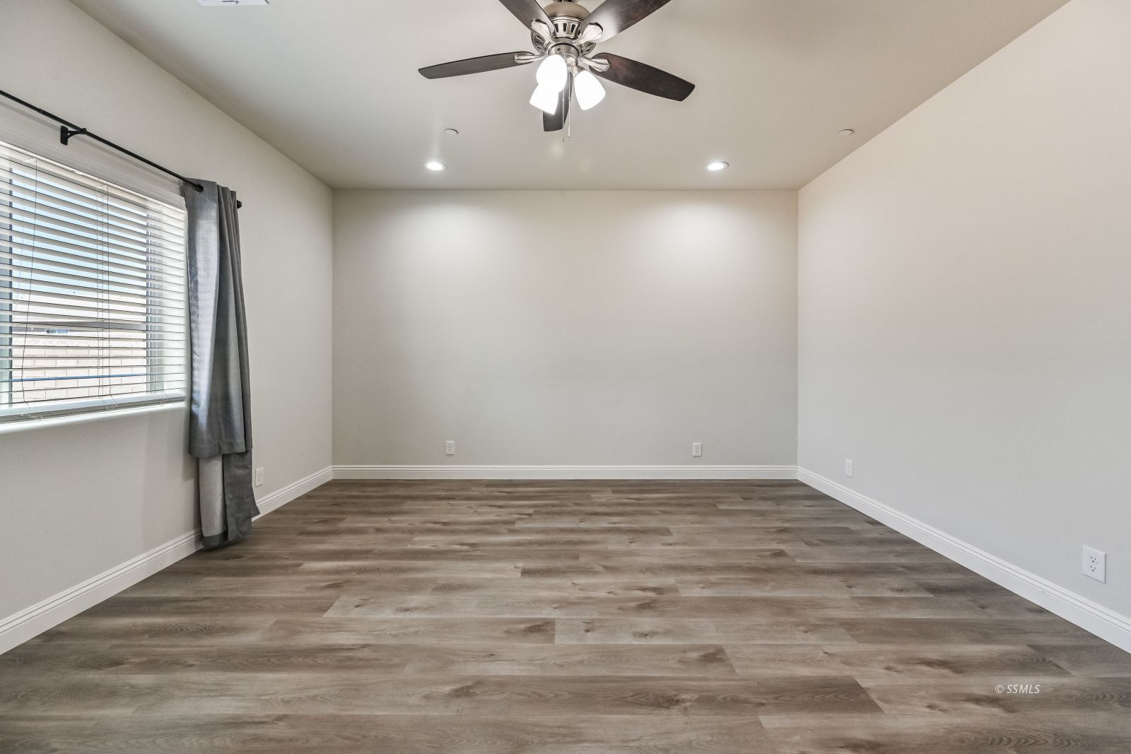 1031 West Church Avenue Ridgecrest, CA 93555 - Photo 27 of 49 a view of an empty room with window and wooden floor