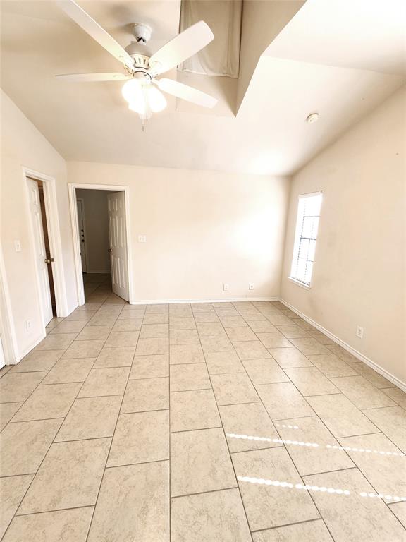 8811 Clearbrook Trail Austin, TX 78729 - Photo 13 of 38 lft A - A spacious room features soaring vaulted ceilings and durable tile flooring.