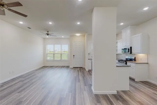 a view of a kitchen with wooden floor and electronic appliances
