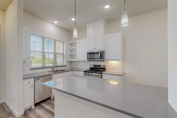 a kitchen with a sink a counter top space appliances and cabinets