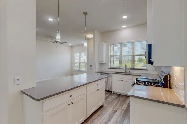 a kitchen with a sink stove and cabinets