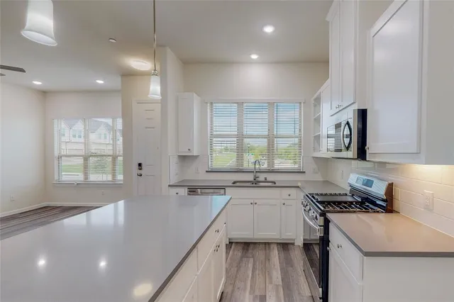 a kitchen with a sink stove and cabinets