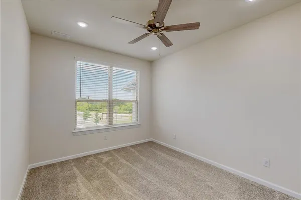 an empty room with a window and a fan