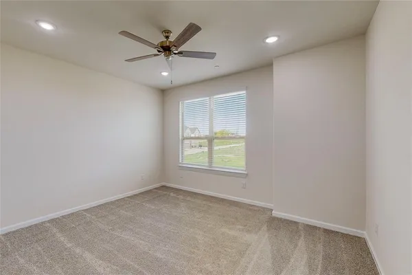 an empty room with a window and a fan