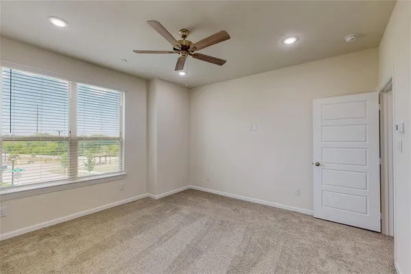 an empty room with a window and a fan
