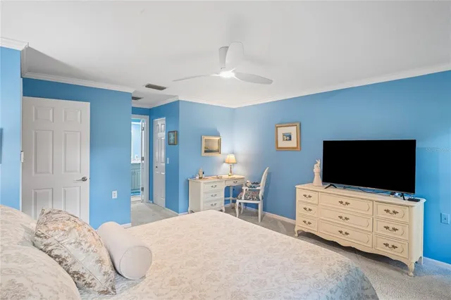 a bedroom with a bed and a flat tv screen on dresser