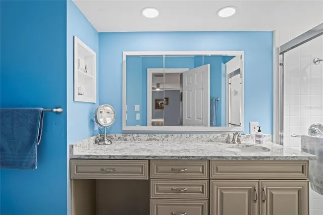 a bathroom with a granite countertop sink and a mirror