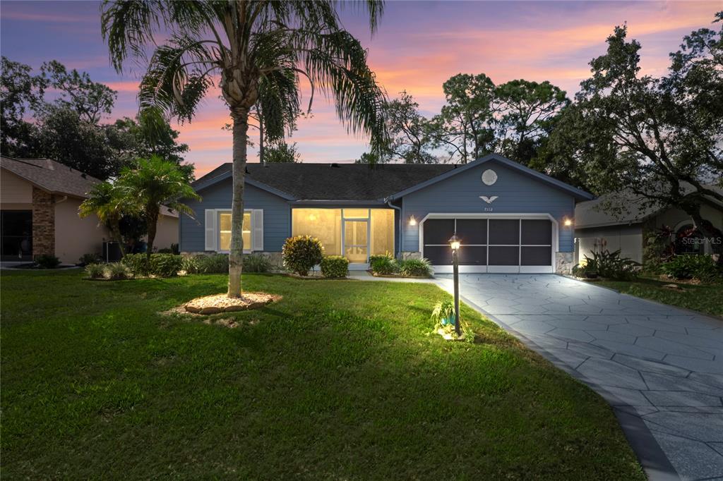 7112 Green Abbey Way Spring Hill, FL 34606 - Photo 3 of 66 a front view of a house with a yard and garage