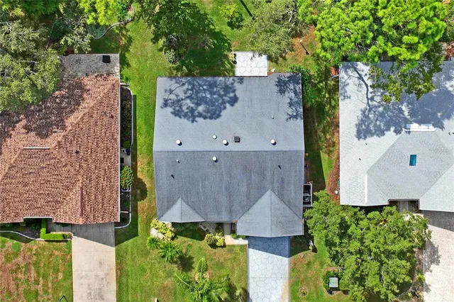 an aerial view of residential houses with outdoor space and trees