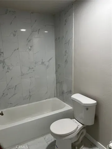 a white toilet and tub sitting next to a bathroom sink