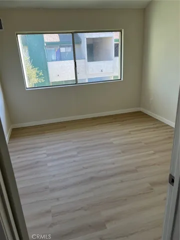 a view of a small space with wooden floor and a window