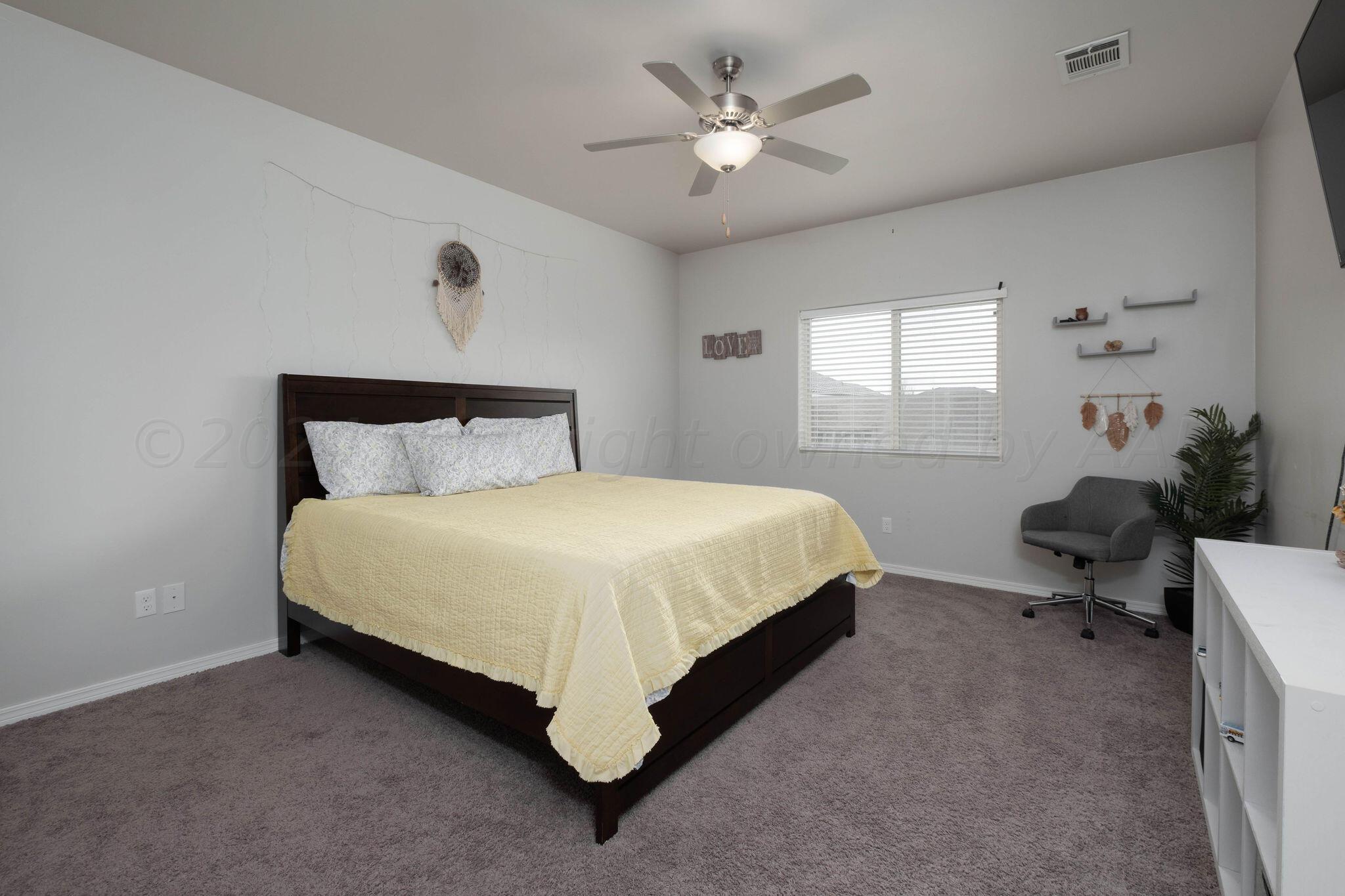 1009 Syrah Boulevard Amarillo, TX 79124 - Photo 15 of 35 a spacious bedroom with a bed and a chandelier