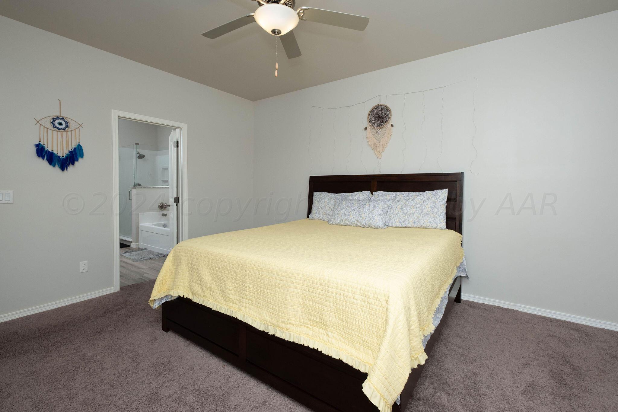 1009 Syrah Boulevard Amarillo, TX 79124 - Photo 17 of 35 a bed sitting in a bedroom and a chandelier