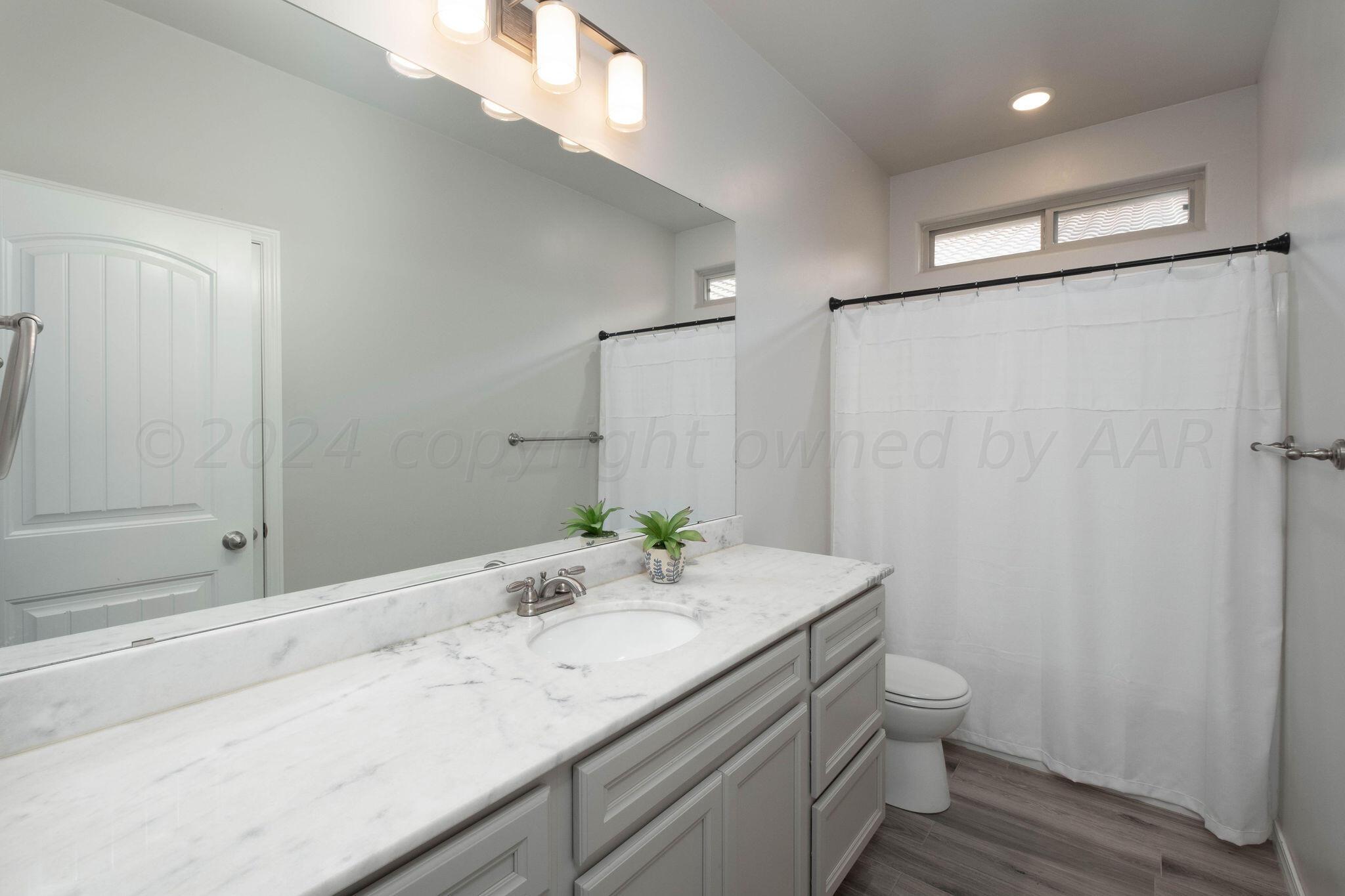 1009 Syrah Boulevard Amarillo, TX 79124 - Photo 25 of 35 a bathroom with a granite countertop sink a toilet and shower