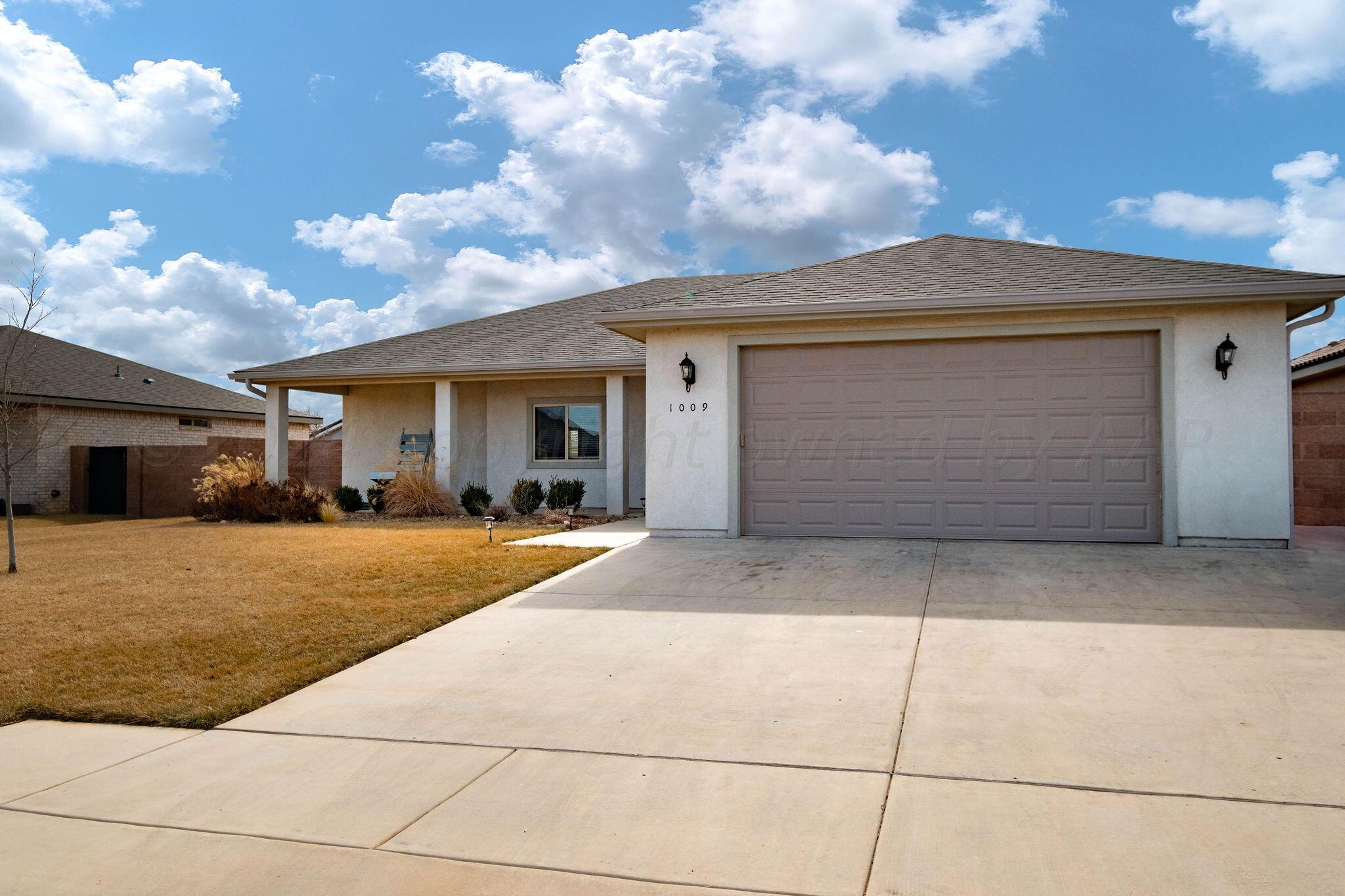 1009 Syrah Boulevard Amarillo, TX 79124 - Photo 3 of 35 a front view of a house with a yard and garage