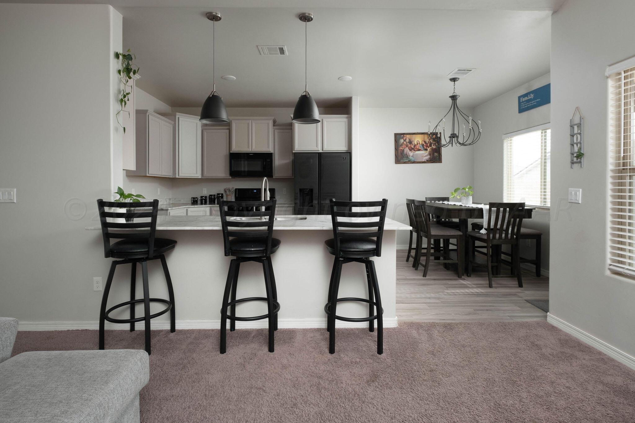 1009 Syrah Boulevard Amarillo, TX 79124 - Photo 8 of 35 a kitchen with stainless steel appliances granite countertop a table chairs and a refrigerator
