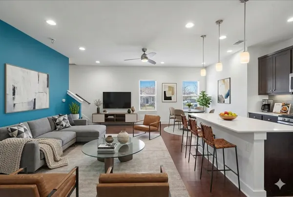 a living room with furniture kitchen view and a flat screen tv